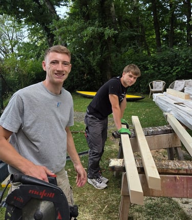 Gut gelaunte Azubis von Holztechnik Volk bei Holzarbeiten im Garten am Ammersee.