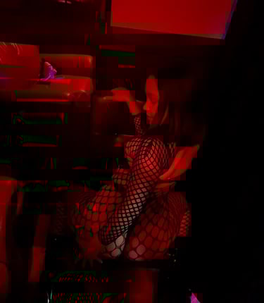 a woman in a fishnet outfit is sitting on a chair