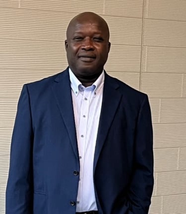 a man in a suit and tie standing in front of a wall