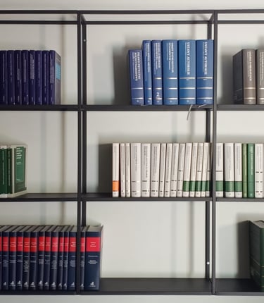 Nowoczesny, czarny regał z uporządkowanymi książkami prawniczymi o różnych kolorach okładek ustawion