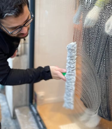 Technicien de M & M Services Pro nettoyant la vitrine du magasin Léo et Ugo à Rouen