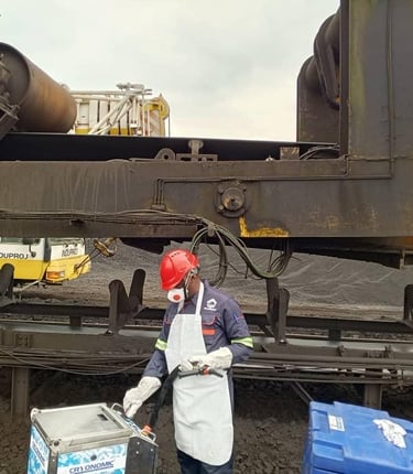 Industrial technician in safety gear performing dry ice blasting on heavy mining machinery.