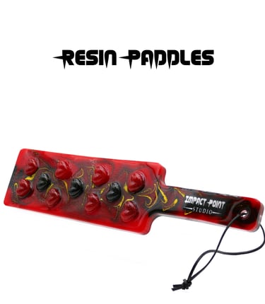 Resin paddle with black and red hearts set into red and black swirly resin with gold glitter.