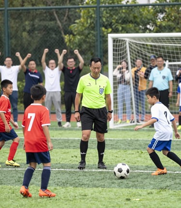 Children in colorful soccer uniforms joyfully playing a match on a sunny Saturday.