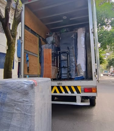 Equipo de Jhony Moving realizando mudanza profesional en CDMX con camión equipado y muebles