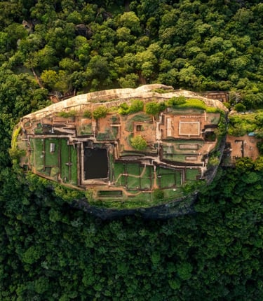 Aerial top-down view of the ancient Sigiriya Rock Fortress ruins surrounded by lush tropical jungle in Sri Lanka.