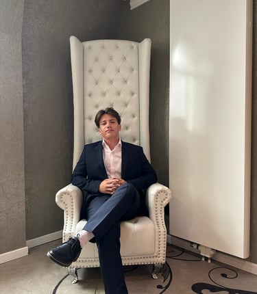 a man in a suit and tie sitting in a chair