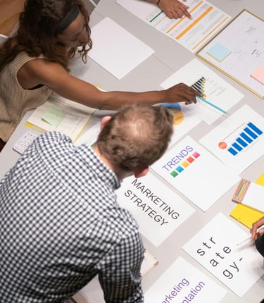A marketing team reviews business growth charts and strategy documents during a planning session.
