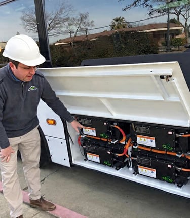 Technician showing the battery packs of a converted EV vehicle