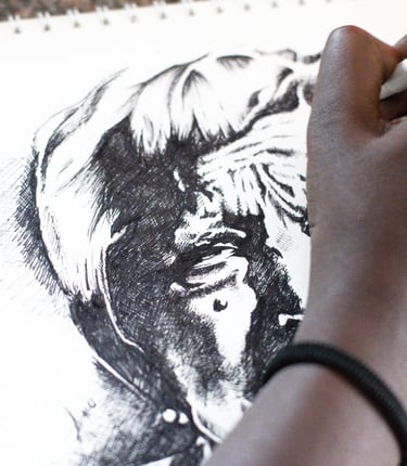 Close up of a woman's hand sketching a portrait with pen.