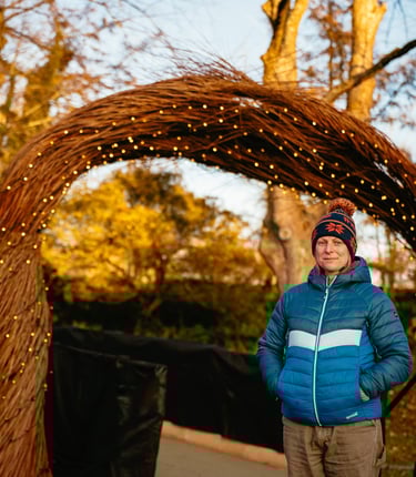 Hannah standing in front of 3m high Willow Arch for Christmas at Bute Park