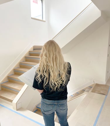 a woman standing in a room with a bookcase