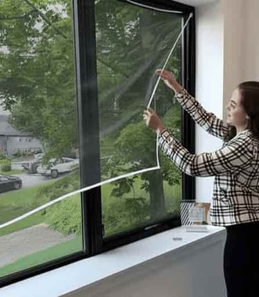 A technician carefully installing a mosquito net on a window in a cozy Sarjapur home.