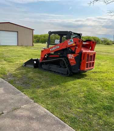 a skidsteer parked in the grass