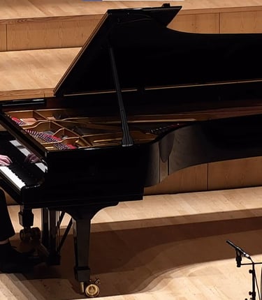 Nathan Reeves playing a piano in a concert hall