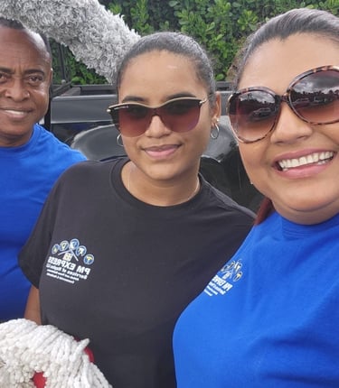 Professional residential cleaning team posing with window washing tools and cleaning supplies.