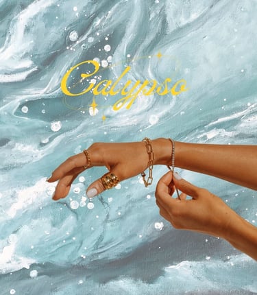 Elegant gold jewelry including rings and bracelets displayed on a hand over blue ocean wave art.