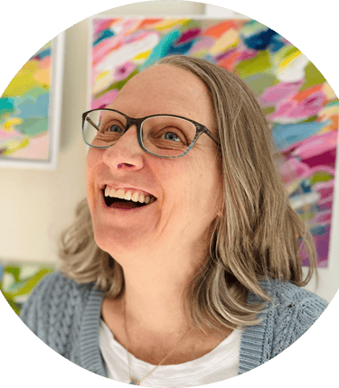 Portrait of artist smiling with colorful abstract painting behind her