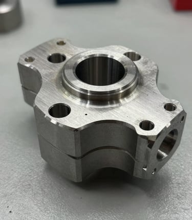 Close-up of a precision-machined metal part resting on a workshop table.