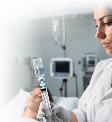 A doctor in a clinic prepares a medical syringe for a patient's stem cell treatment.