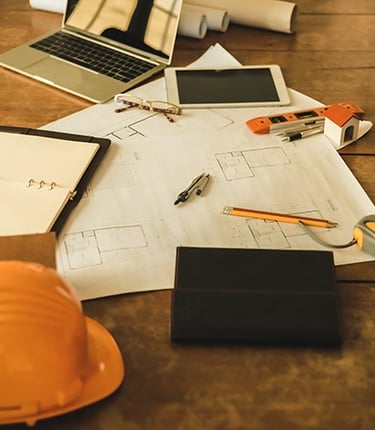 Laptop, capacete e ítens importantes para profissional de construção