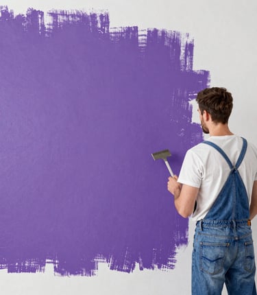 Professional painter carefully applying white paint on apartment wall with protective floor covering in Porto Alegre.