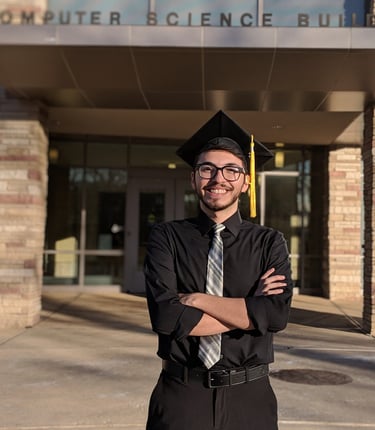 2014, recently graduated Luis posing in front of his Computer Science department.