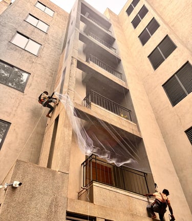 A technician carefully installing a sturdy pigeon net on a sunny Mumbai balcony.