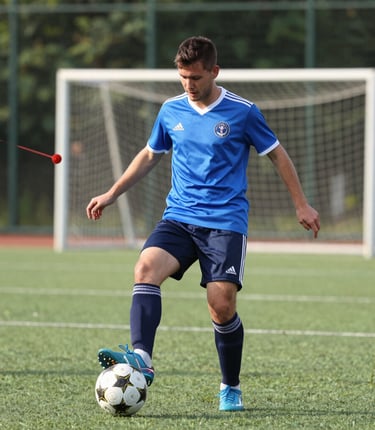 A vibrant indoor futsal match with players celebrating a goal under bright lights.