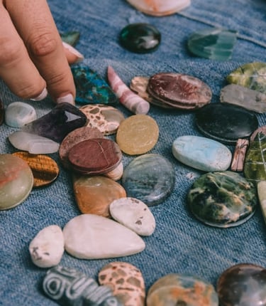 Selección de piedras y minerales naturales para joyería artesanal hecha a mano sobre tela azul.