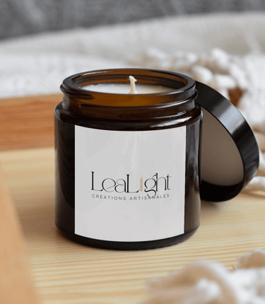 LeaLight handmade soy candle in an amber glass jar on a wooden tray with a cozy blanket.