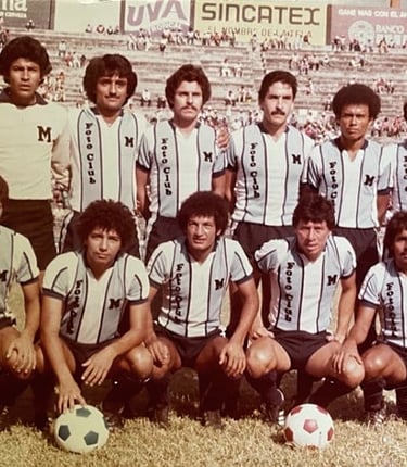 Vintage team photo of a classic soccer squad in light blue striped jerseys posing on the pitch.