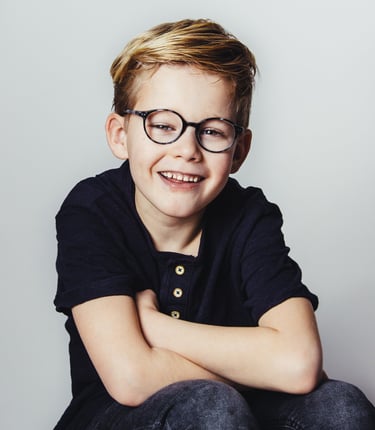 portret of a young boy with glasses and a black shirt