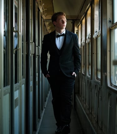 portret jongeman in smoking treincoupe