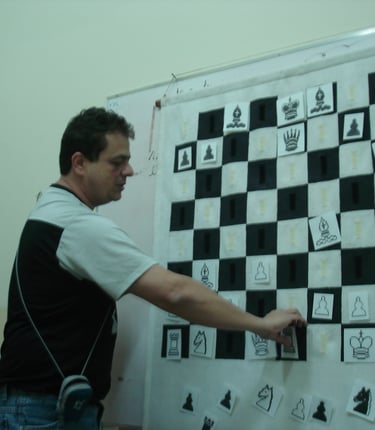 Reinaldo Mano durante uma aula de xadrez, movendo as peças em um quadro tabuleiro