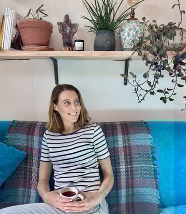 a woman sitting on a couch with a cup of coffee