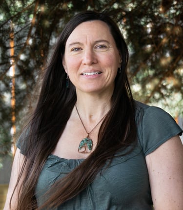a woman with long hair and a necklace with a green leaf