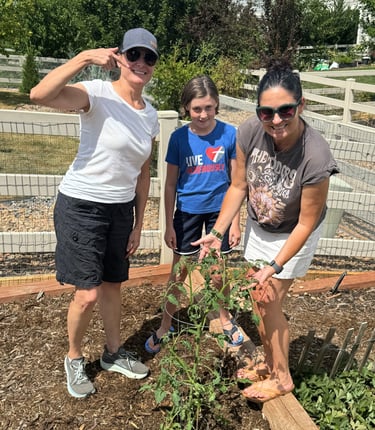 Prepped & Planted coach with clients excited about their growing tomato plant.
