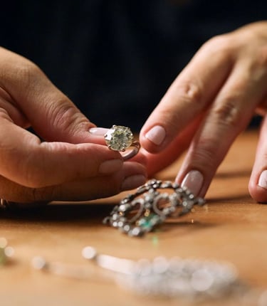 a woman's hands holding a solitaire diamond ring