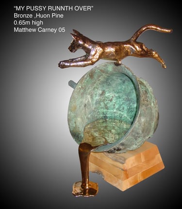 a bronze sculpture of a cat jumping over a teacup