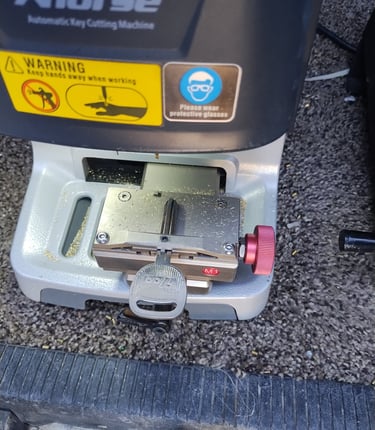 machine cutting a new car key replacement