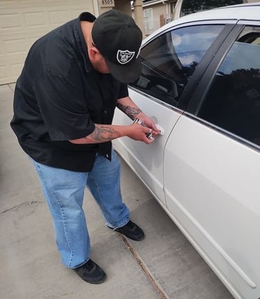 a man in a black shirt is unlocking a car