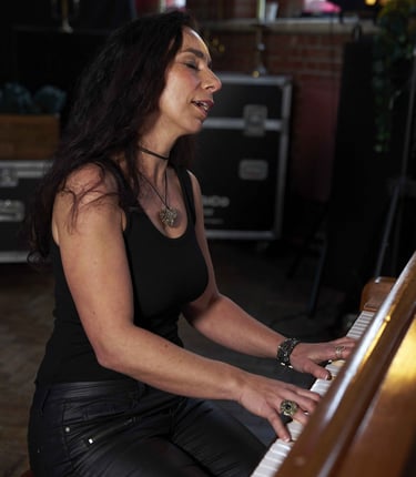 Helen Spooner playing piano on an antique piano, creating elegant live music.