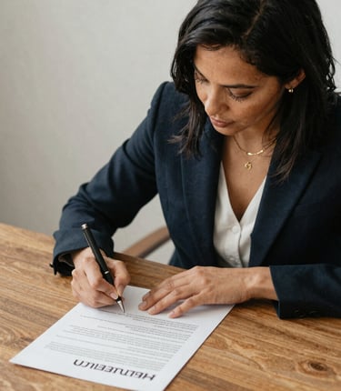 A professional notary in a blue shirt carefully reviewing documents at a client's home office.