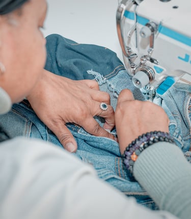 Modista arreglando un pantalon jeans en el taller de la costura