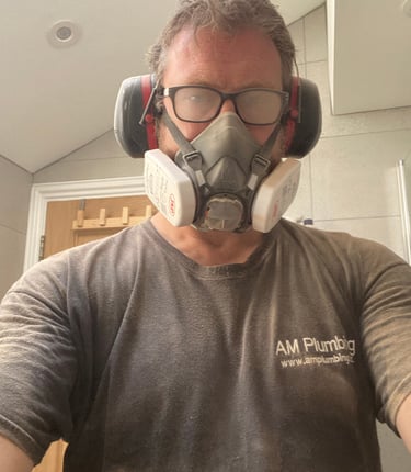 A very dusty owner of AM Plumbing after cutting through porcelain tiles to get to a leaking valve behind a tiled wall