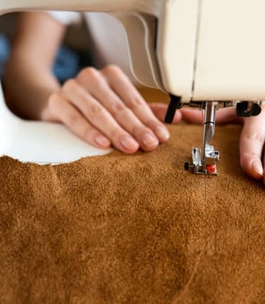 person sewing brown leather
