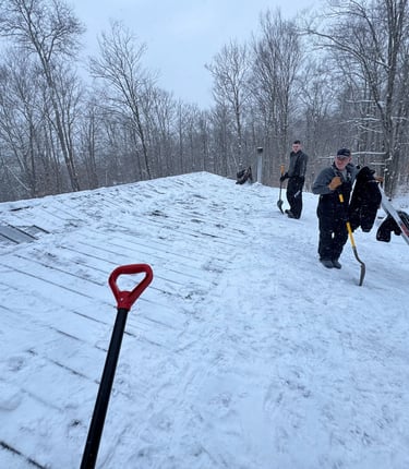 A crew of men shoveling a roof