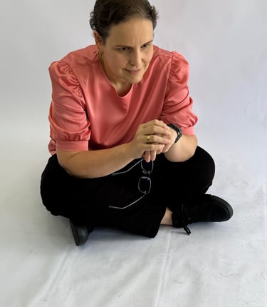 a woman sitting on a white sheet with a cell phone