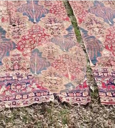 Antique rug with severe tearing and damaged sections before professional restoration